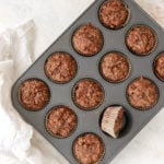 Coconut Carrot Muffins in a 4x3 steel muffin tin with one muffin turned on it's side