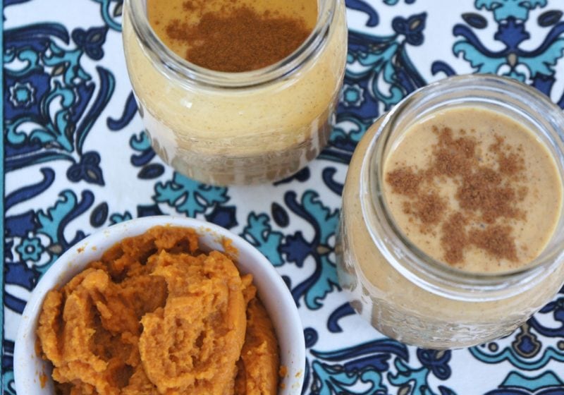 Two Creamy Pumpkin Spice smoothie in mason jars with a bowl of pumpkin puree placed beside them. Ingredients include Greek yogurt, almond milk, almond milk, banana, pumpkin puree, cinnamon, vanilla.