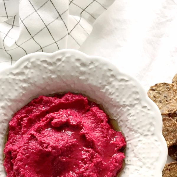 Roasted Red Beet Hummus in a white round serving dish. Ingredients include red beets, avocado oil, chickpeas, lemon, garlic, tahini, water, black pepper.