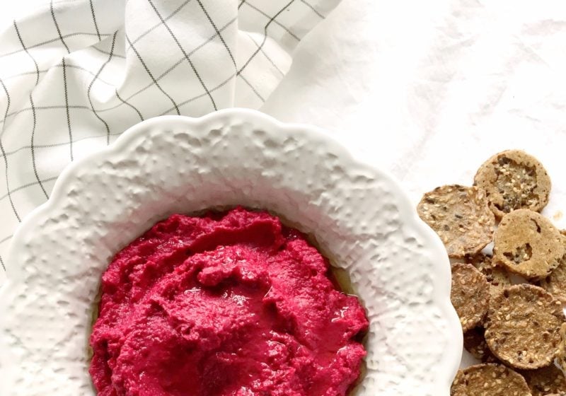 Roasted Red Beet Hummus in a white round serving dish. Ingredients include red beets, avocado oil, chickpeas, lemon, garlic, tahini, water, black pepper.