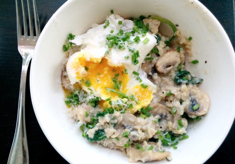 10 minute savory oats with poached egg are in a white bowl. The yolk is cracked and topped with green onion.