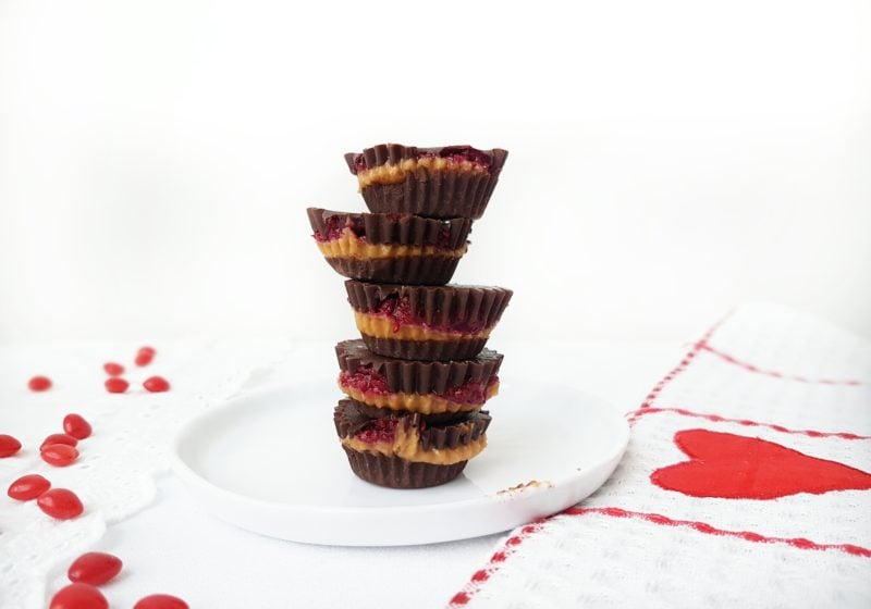 Chocolate PB & J Cups piled on a round white plate. Ingredients include chocolate, chia jam, peanut butter.