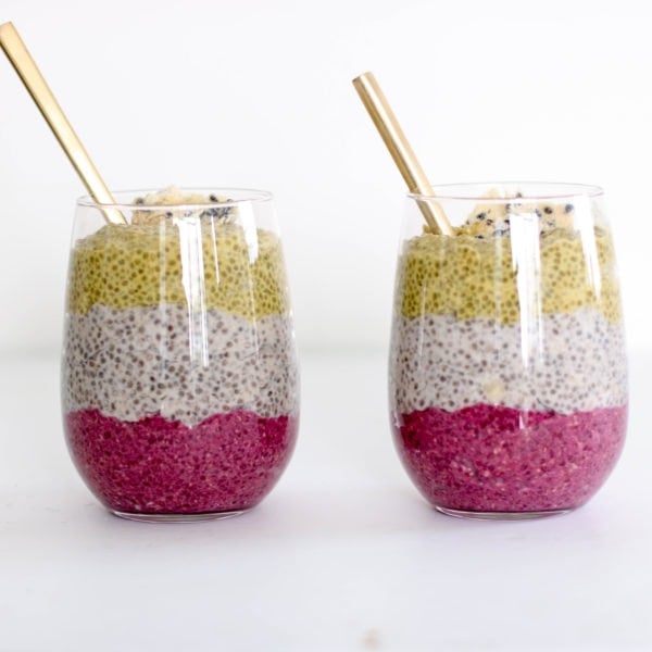 Two glass jars filled with chia pudding with a straw. Ingredients include chia seeds, milk, turmeric, maple syrup.