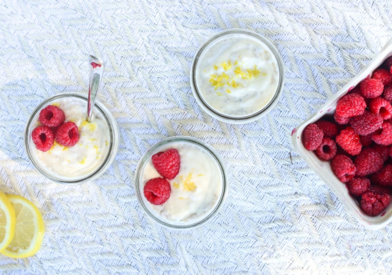 A photo of 3 jars filled with 4 Ingredient Lemon Coconut Chia Pudding (No Bake). Ingredients include Activia yogurt, coconut milk, lemon zest, chia seeds, and berries.