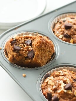 One bowl chocolate chip oat flour pumpkin muffins made with oat flour, pumpkin puree, creamy natural peanut butter, and chocolate chips.