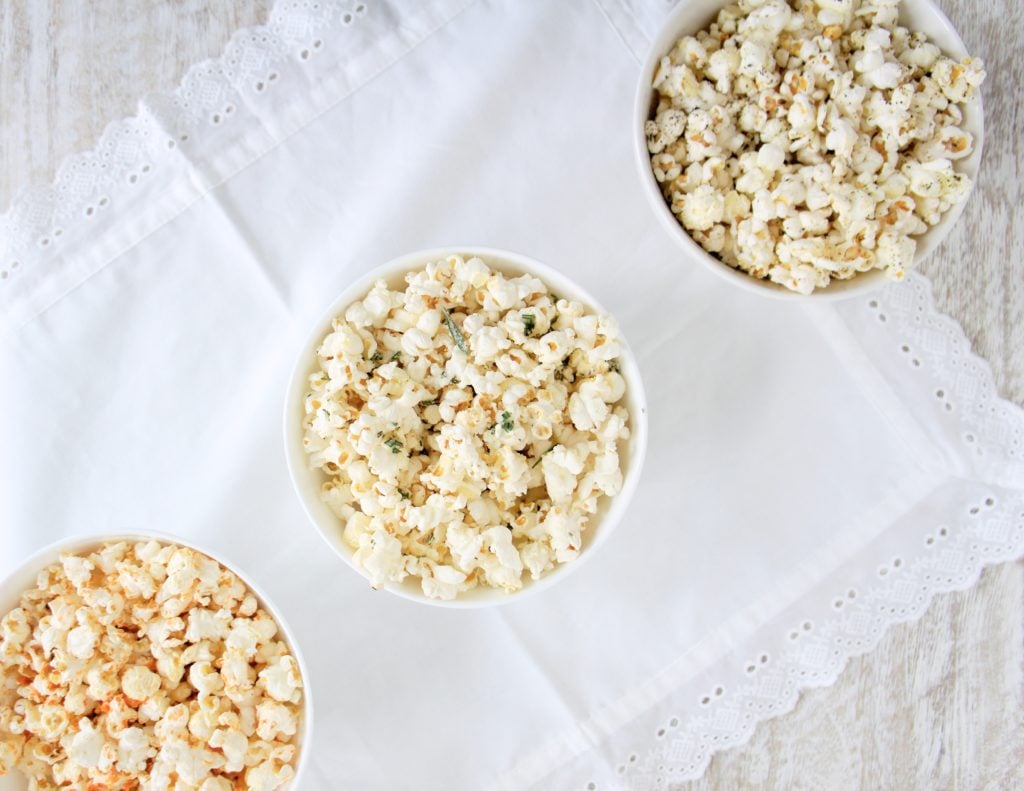 Popcorn three ways. Ingredients include: popcorn, Sriracha Lime, Rosemary Parmesan and Olive oil with Sea Salt and Fresh Cracked Pepper