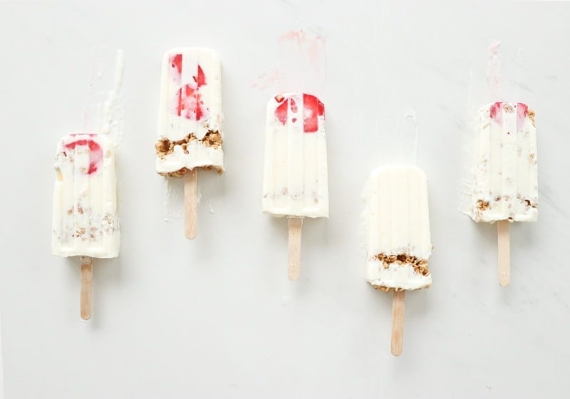 3 ingredient high protein lemon cheesecake smoothie pops laid out on a white surface.