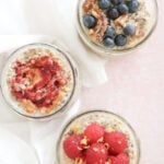 The simple overnight oats base recipe is divided into 3 small mason jars. One is topped with blueberries and toasted walnuts, one is topped with raspberries and lemon zest and one is topped with peanut butter and jelly