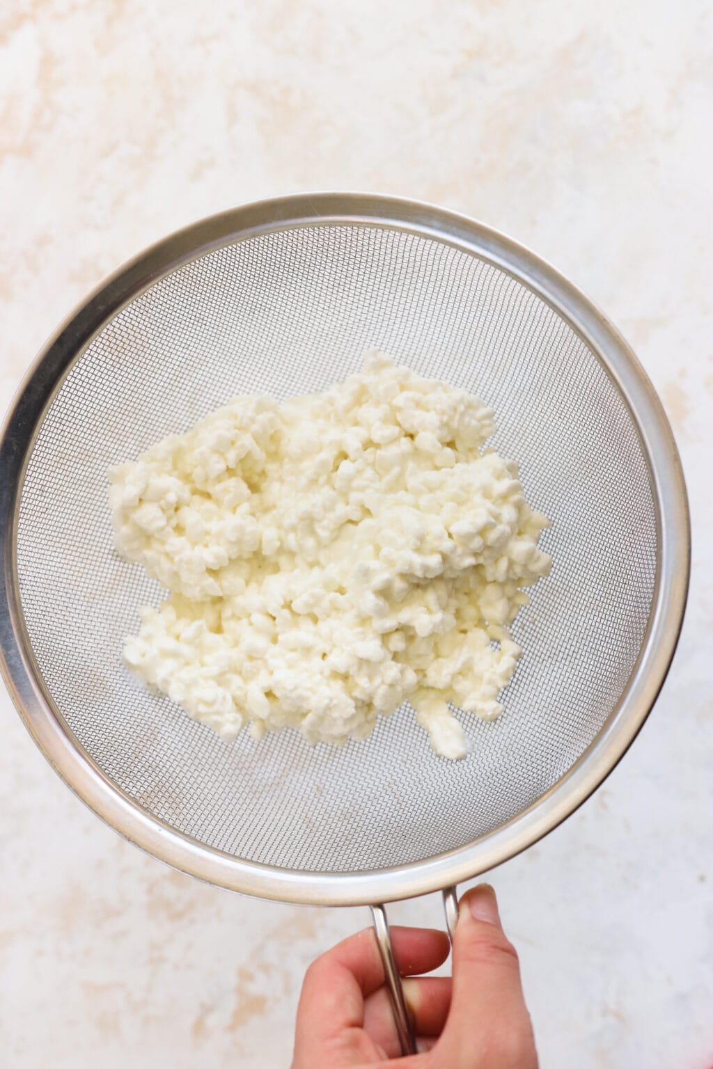 Cottage cheese in a metal strainer