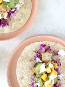 Two plates with open-faced cajun fish tacos