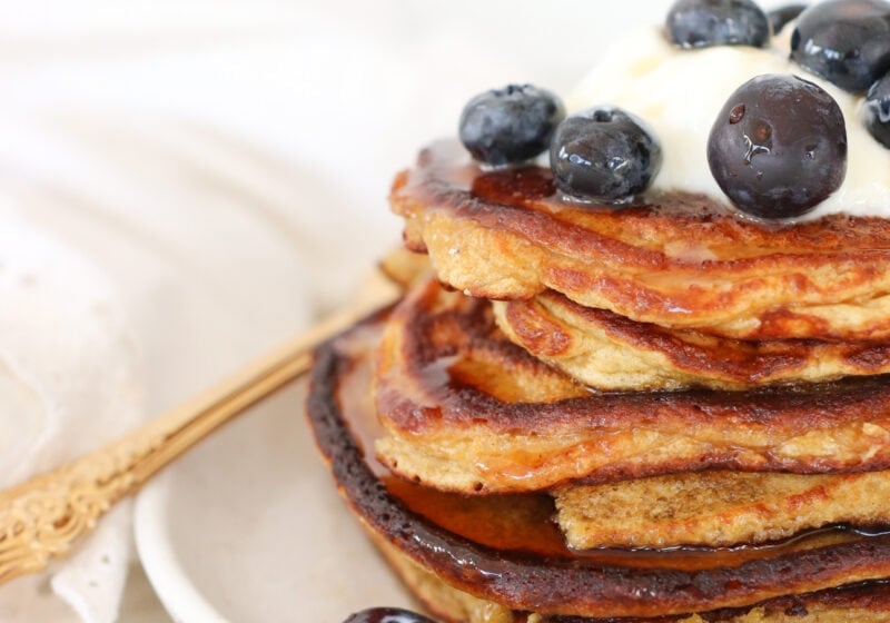 A stack of cottage cheese pancakes topped with Greek yogurt and blueberries.