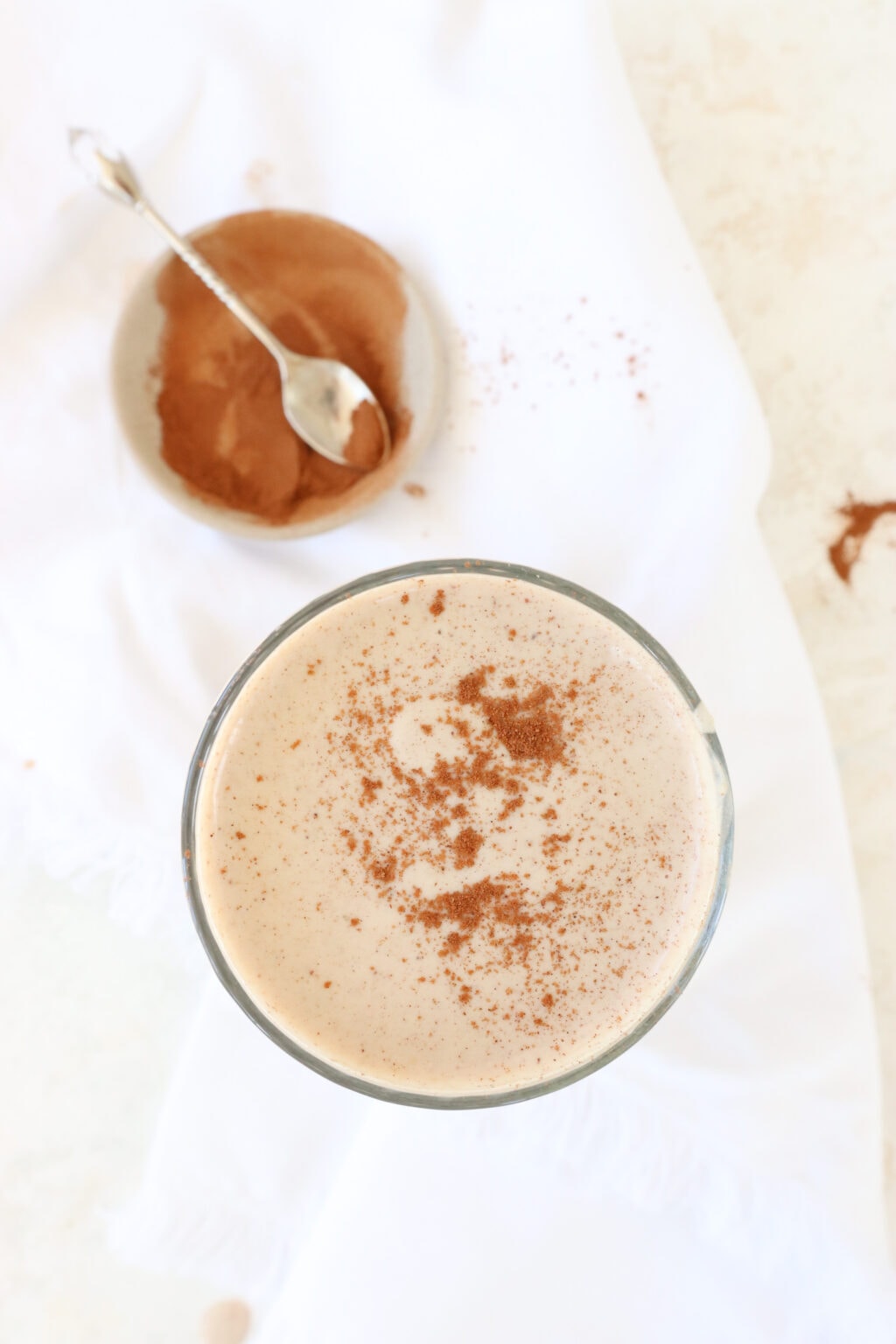 Cinnamon Roll Smoothie in a glass topped with fresh cinnamon