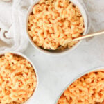 5 Ingredient Creamy Cottage Cheese Mac and Cheese in three white bowls on a white table