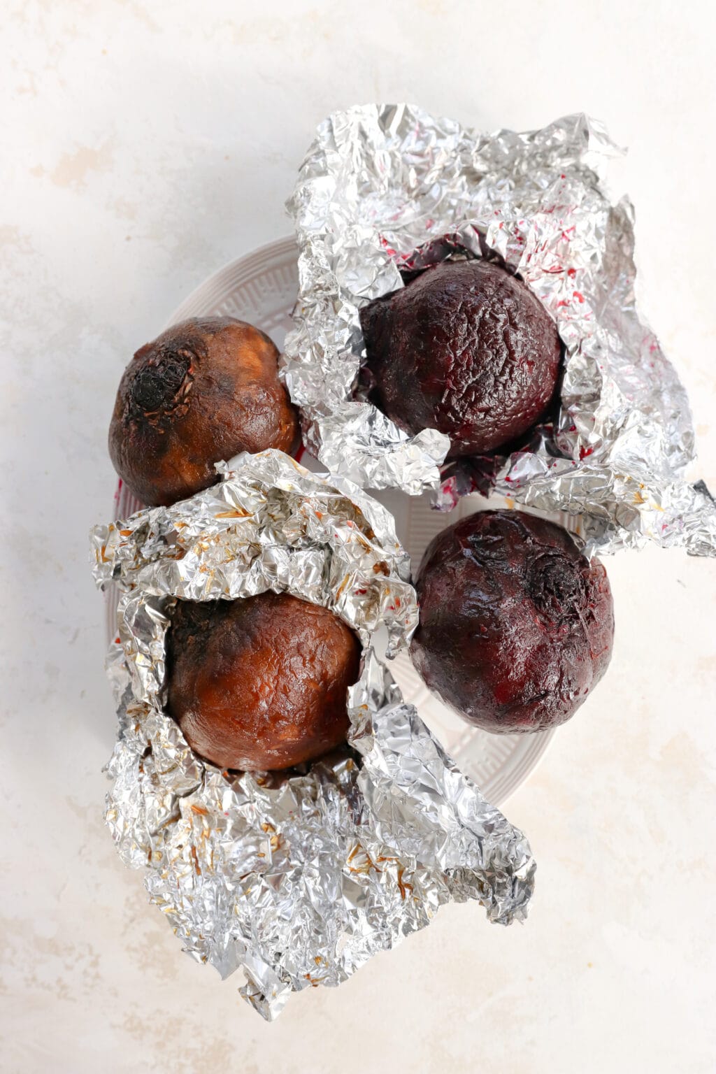Four beets wrapped in foil for making blood orange roasted beet salad with creamy yogurt dressing