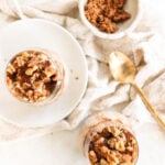 Brown sugar and Greek yogurt overnight oats in three glass bowls on top of a soft, cream-colored tablecloth with a gold spoon