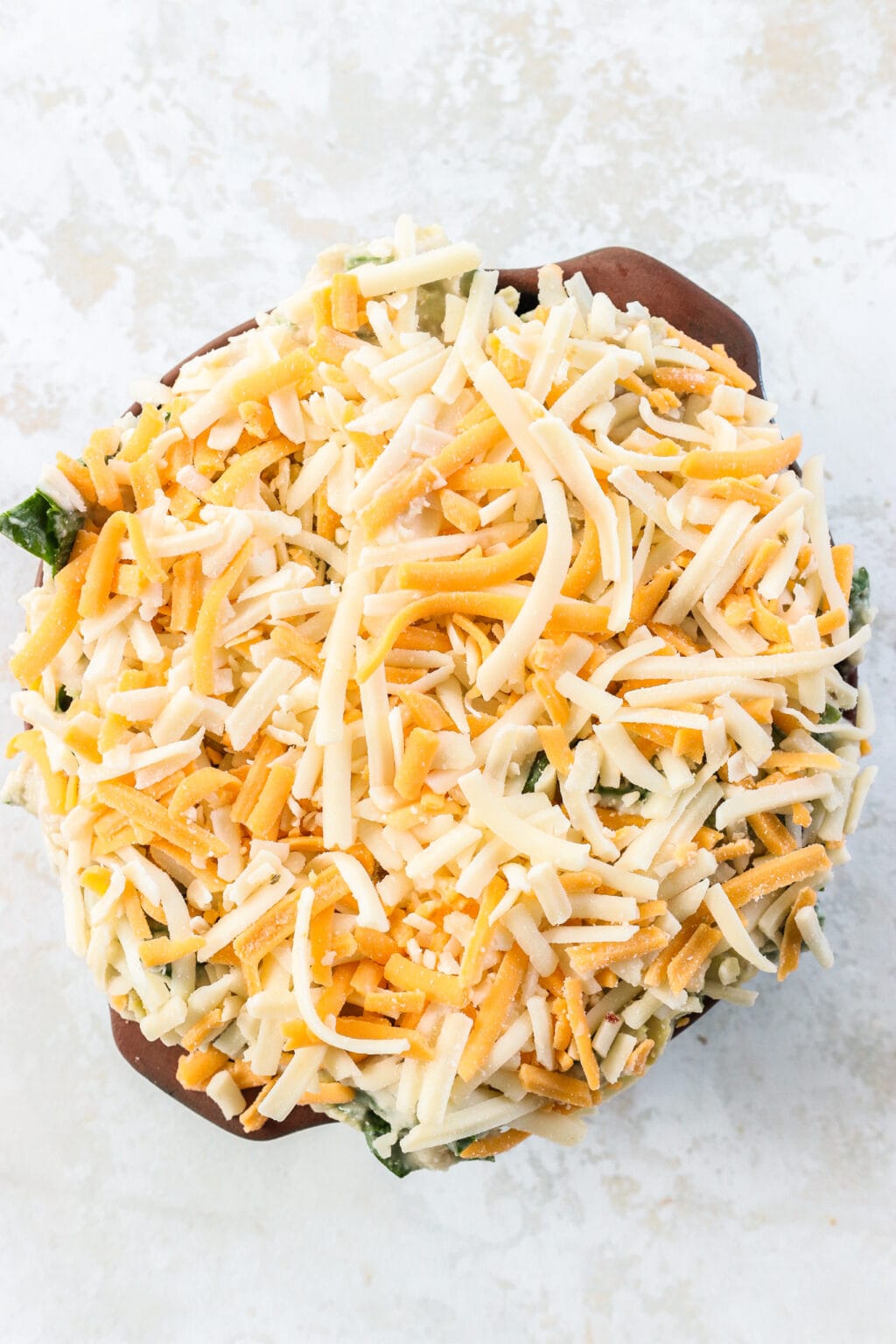 A dish of healthy white bean, spinach and artichoke dip before it is baked