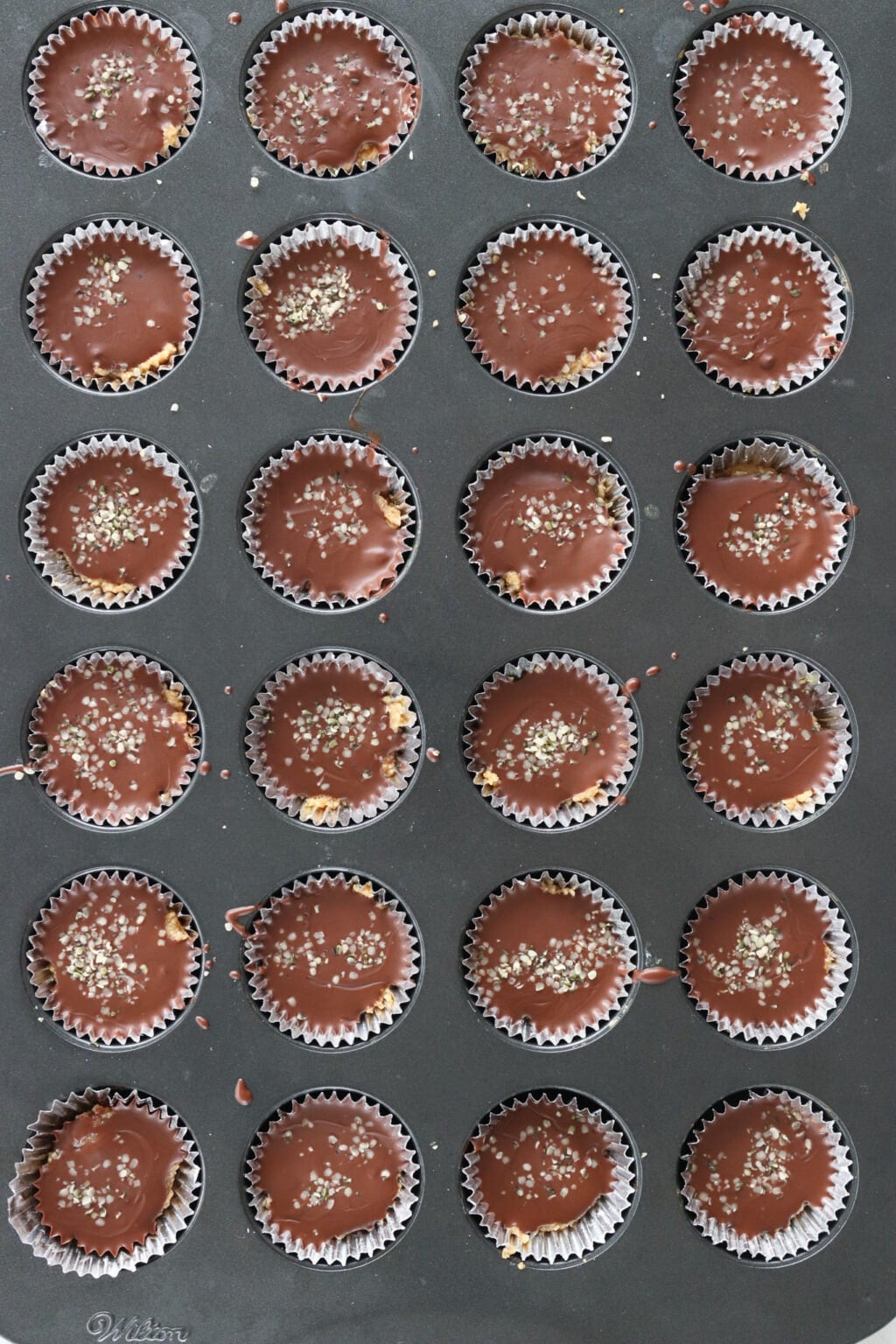 A muffin tin of No Bake Peanut Butter & Chocolate Protein Bars on a marble counter