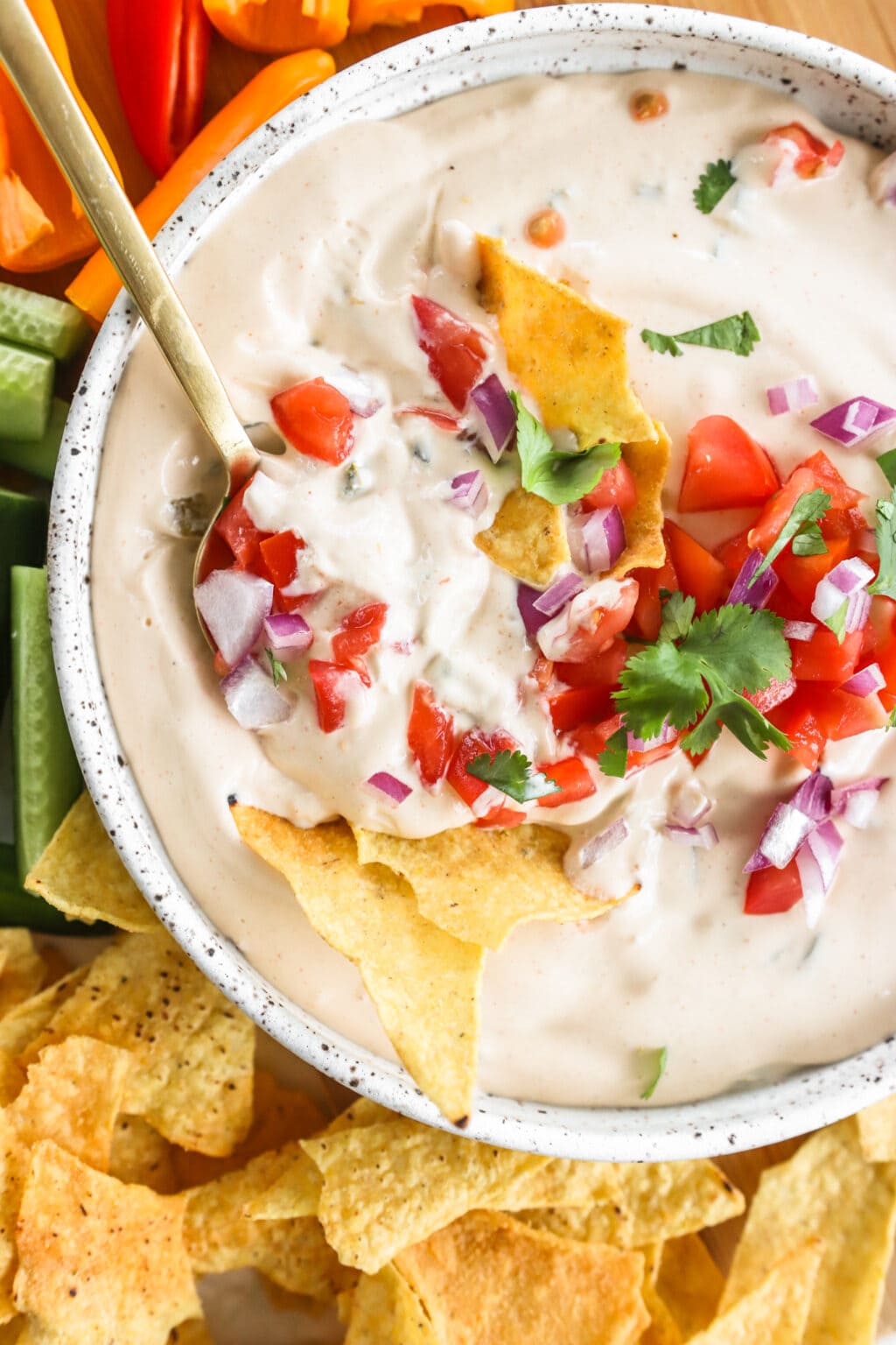 5-Minute Warm Queso Dip With Cottage Cheese in a white bowl with celery, red peppers, and tortilla chips on the side