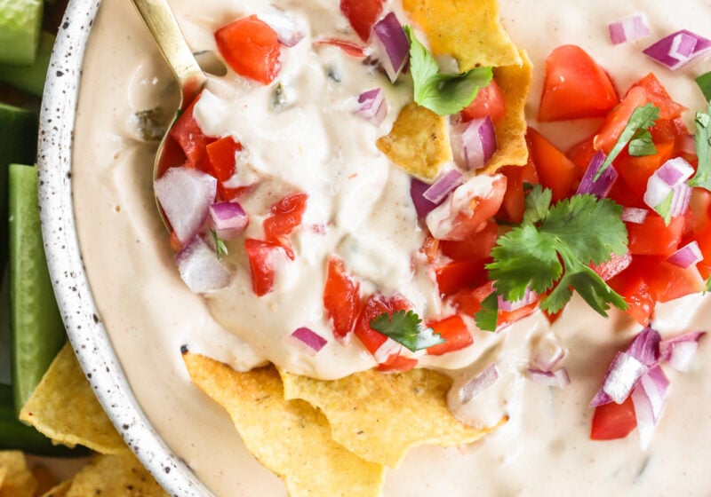 5-Minute Warm Queso Dip With Cottage Cheese in a white bowl with celery, red peppers, and tortilla chips on the side