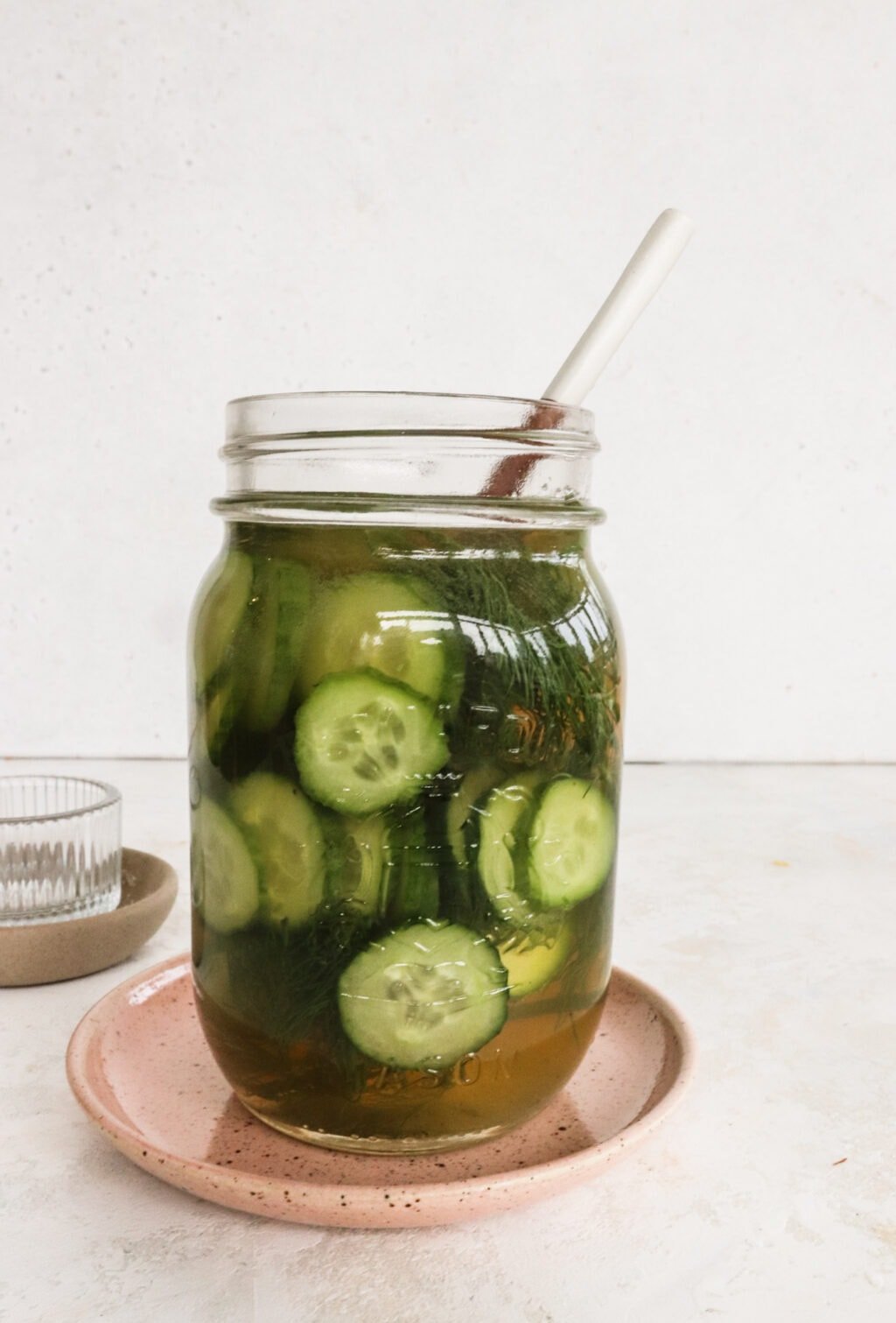 Apple Cider Vinegar Cucumber Pickles with Dill in a pickle jar with a wood spoon