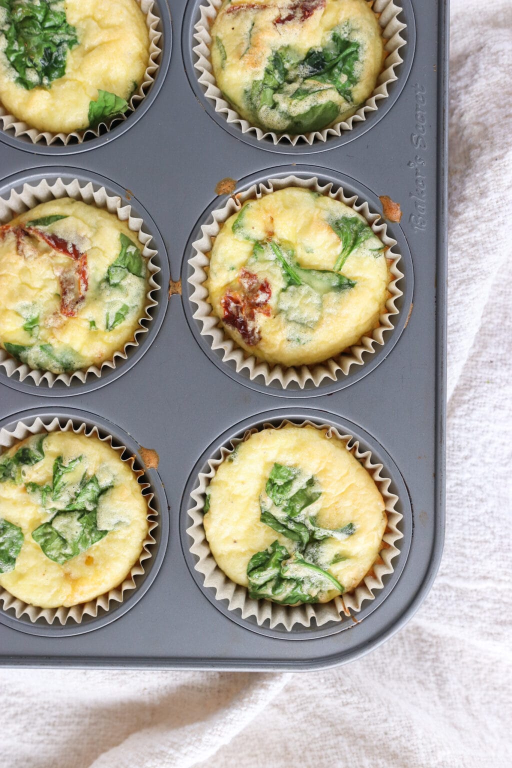 Egg Bites with Cottage Cheese, Spinach & Sun-dried Tomatoes in a muffin tin