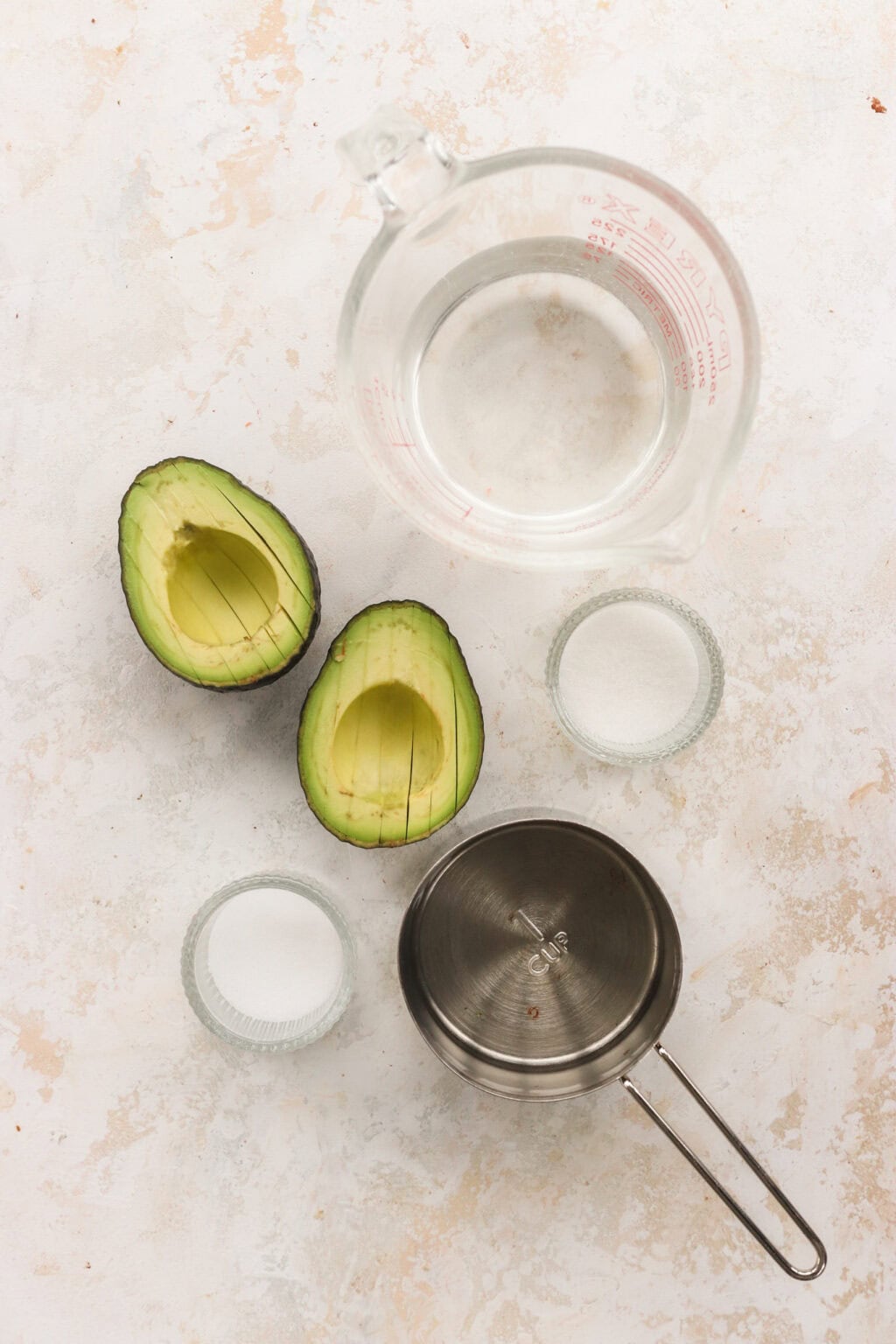 Ingredients for quick pickled avocados, including avocados, sugar, salt, vinegar, and hot water