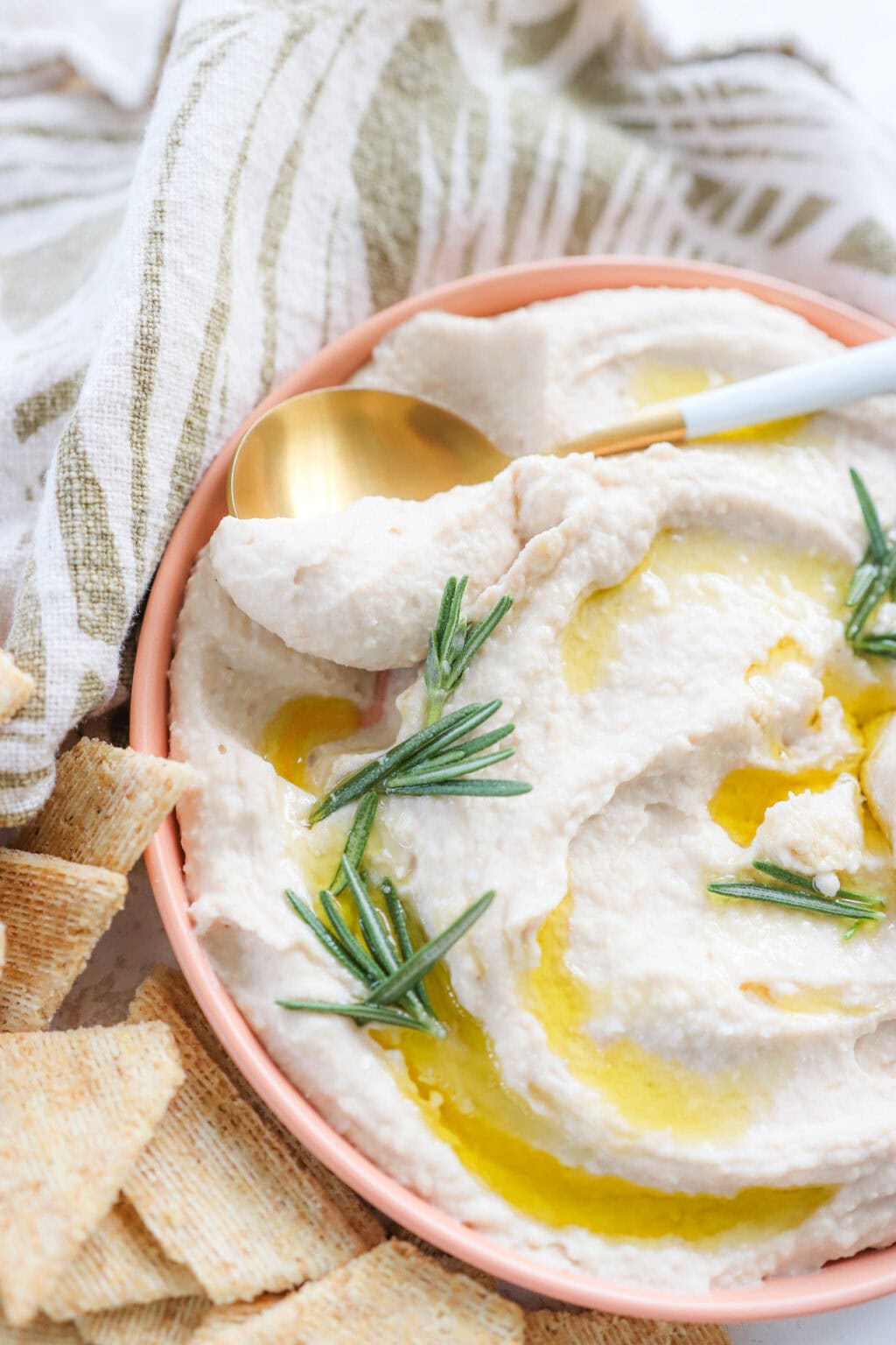Super Creamy Vegan White Bean Dip with Cashews in a pink bowl with crackers on the side
