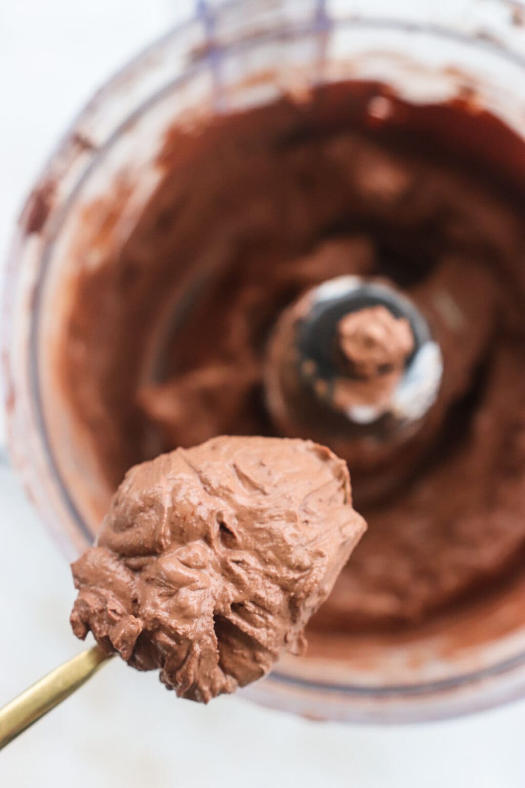 Ingredients for Whipped Greek Yogurt Chocolate Mousse blended in a food processor, including chocolate chips, Greek yogurt, cacao and salt