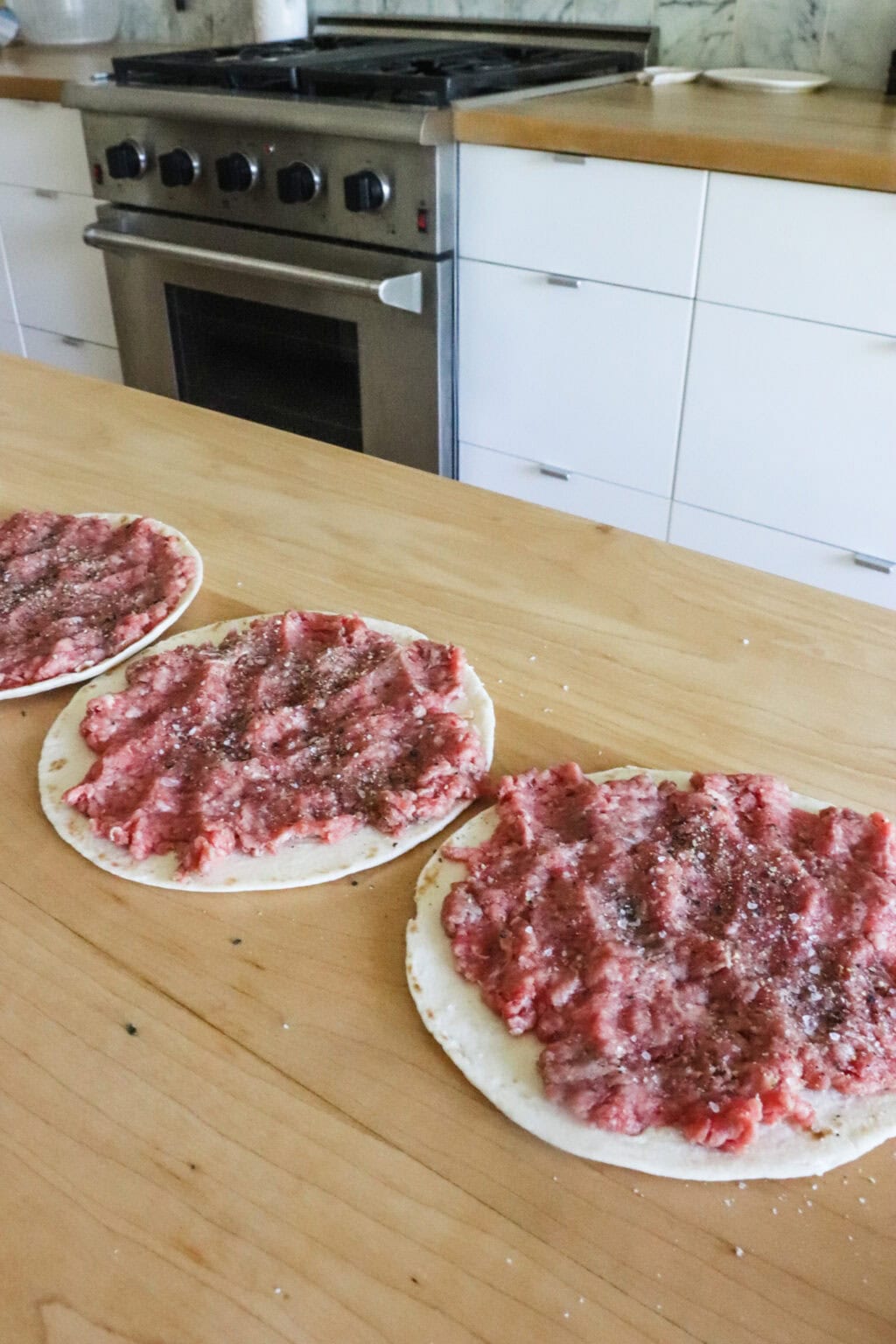 Smashed ground beef on flour tortillas for the Quick Pan Fried Smash Burger Tacos with Ground Beef