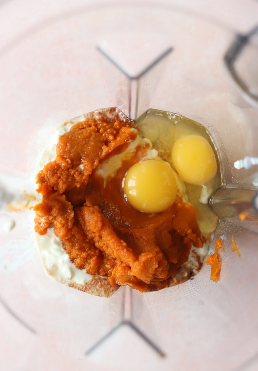 Ingredients for High Protein Pumpkin Pancakes with Cottage Cheese unblended in a blender, including quick oats, pumpkin puree, cottage cheese, milk, eggs, baking powder, maple syrup, pumpkin pie spice, avocado oil