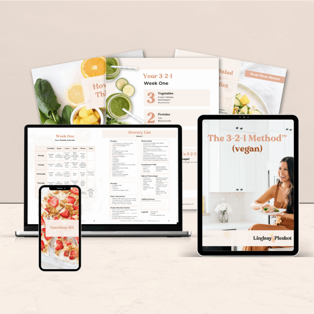 Digital devices display a vegan meal planning guide called The 3-2-1 Method. The image also includes recipe pages, a grocery list, and nutrition tips, against a light background with fresh fruits and vegetables.